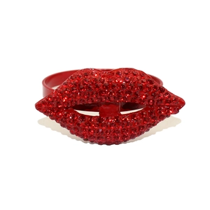 Detailed macro view of a red lip-shaped napkin ring adorned with sparkling rhinestones