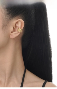 Detailed view of a gold woven texture ear cuff with intricate lattice design on ear