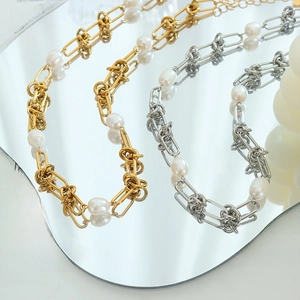 French vintage gold and silver titanium necklaces with freshwater pearls on a mirror