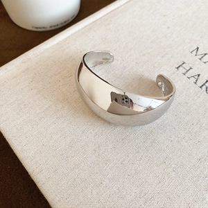 Vue macro détaillée du bracelet manchette argenté poli sur un livre esthétique