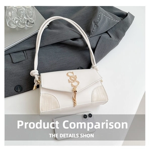Detailed macro view of cream shoulder bag with golden SS logo and metal tassel accent