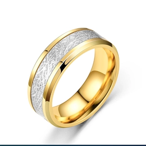 Detail of two-tone titanium steel ring featuring gold edges and textured silver center inlay