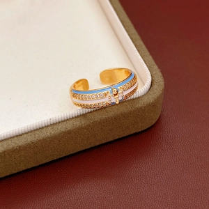 Detail of 18k gold plated ring with blue enamel, fleur-de-lis and zircon stones