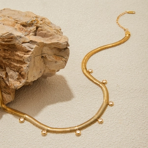 Classic 18K gold snake chain necklace with white cubic zirconia charms on neutral stone