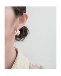 Detail of minimalist 18K gold plated hoop earrings with white enamel finish on ear