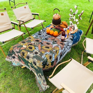 Detail of bohemian sunflower woven blanket with tassels used as a picnic mat outdoors