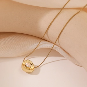 Elegant gold plated necklace with irregular geometric pendant and oval zircon on silk fabric