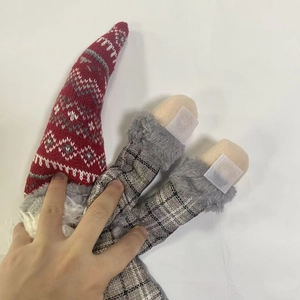 Detail of Christmas gnome curtain tieback with red knitted hat and gray plaid fabric