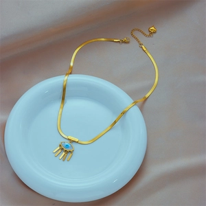 Gold evil eye necklace with tassel fringe and lucky engraving on flat snake chain