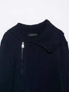 Detail of the navy blue ribbed knit cardigan featuring a silver metal zipper and collar