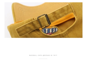 Close-up of adjustable metal buckle and stitching on yellow cotton baseball cap back
