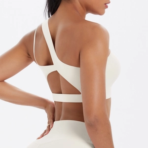 Close-up of cream sports bra featuring asymmetrical one-shoulder strap and cut-out back