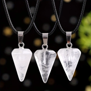 Three natural white crystal hexagonal pendant necklaces with black cords on bokeh background