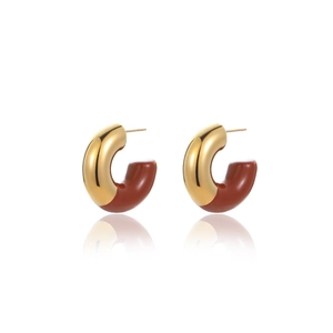 Macro view of C-shaped 18k gold hoop earrings with brown enamel and polished reflections