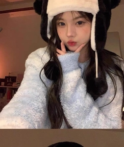 Close-up of the plush texture on a cute penguin-themed winter hat with ear flaps