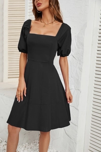 Detailed view of the square neckline and puff sleeves on this black A-line mini dress
