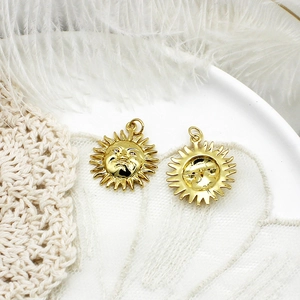 Close-up of golden sun face pendants on white plate with soft feather decoration