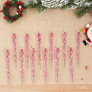 Detail of pink transparent spiral icicle ornaments hanging on a snowy Christmas tree branch