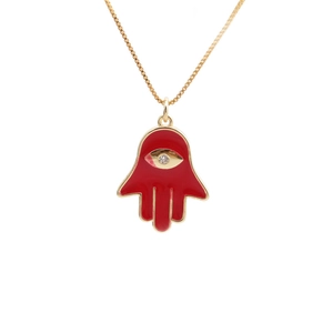 Golden Hamsa hand necklace with red enamel palm and sparkling zircon on white background