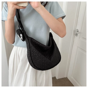 Detail of black pleated cloud puff bag featuring a small zipper pouch on shoulder strap