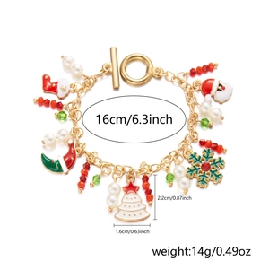 Detail of Christmas bracelet with Santa, snowflake charms and faux pearls on gold chain