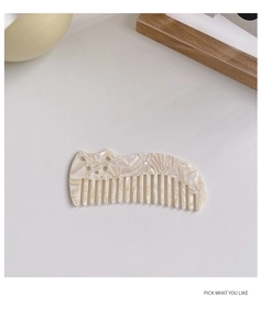Detail showing marble texture on a cute cat-shaped acetate hair comb in cream finish