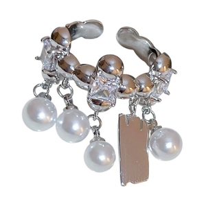 Elegant silver ear cuff with sparkling zircons, dangling pearls and a metal charm tag