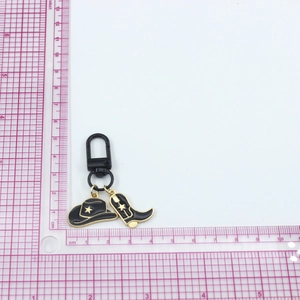 Detailed view of western cowboy hat and boot charms on black metal keychain clip