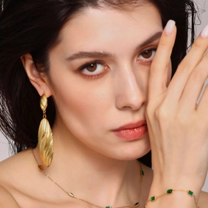 Elegant 18k gold plated long shell pendant earrings with striped texture on female model