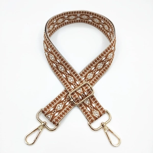 Detailed view of jacquard ethnic strap with geometric diamond patterns and gold metal hook