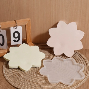 Close-up of lotus-shaped silicone coaster molds in green, pink, and translucent finish