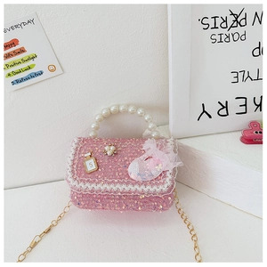Detail of pink sequin girl's purse with pearl handle, lace trim and gold chain