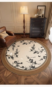 Top view of a round beige rug with brown border and floral butterfly pattern in a living room