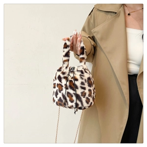 Detail of leopard print plush bucket bag with metal chain strap and drawstring closure