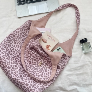 Detail view of pink leopard print tote bag interior with inner pocket and woven brand label