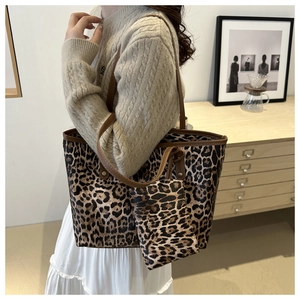 Detailed view of leopard print tote bag with matching small pouch in a modern interior setting