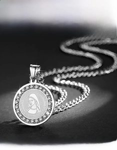 Detailed macro of silver stainless steel pendant with Virgin Mary and Greek fret pattern