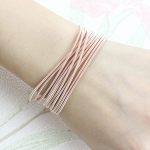 Bracelet à ressort multicouche en or rose sur le poignet d'un mannequin femme