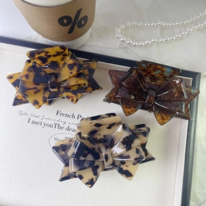 Three elegant acetate bow hair claws with classic tortoiseshell patterns in a vintage style