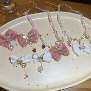 Detailed view of bowknot pearl bracelets and hairpins with star pendants on a tray