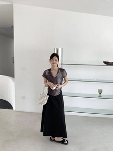 Detail of V-neck tie-dye short sleeve t-shirt paired with a black straight long skirt
