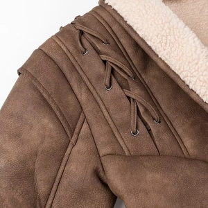 Detail of faux shearling lining and leather lace-up sleeve on brown biker jacket