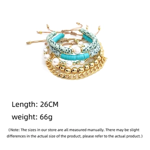 Detail view of Bohemian layered bracelets with gold chains, pearls and green clay beads