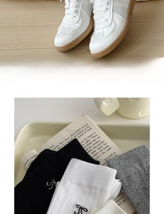 Detail of ribbed cotton calf socks with embroidered bows and vintage sneakers