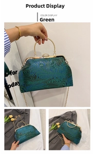 Detail of green vintage clutch bag with peacock feather embroidery and metal ring handle