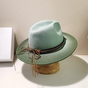 Close-up of the gradient green wool fedora with sequined band and brown fringe bow detail
