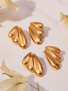 Close-up of geometric fan-shaped 18k gold plated stainless steel earrings on marble