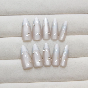 Unghie finte cat eye con motivi a stella e luna e strass su forma a mandorla lunga