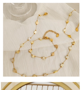 Detailed macro view of 18k gold plated star pendant jewelry set on white silk