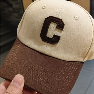 Detailed close-up of the beige and brown color-block baseball cap with chenille letter C